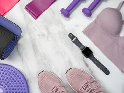 Utensilios de entrenamiento de una mujer: playeros, reloj, cintas elásticas, mancuernas y más