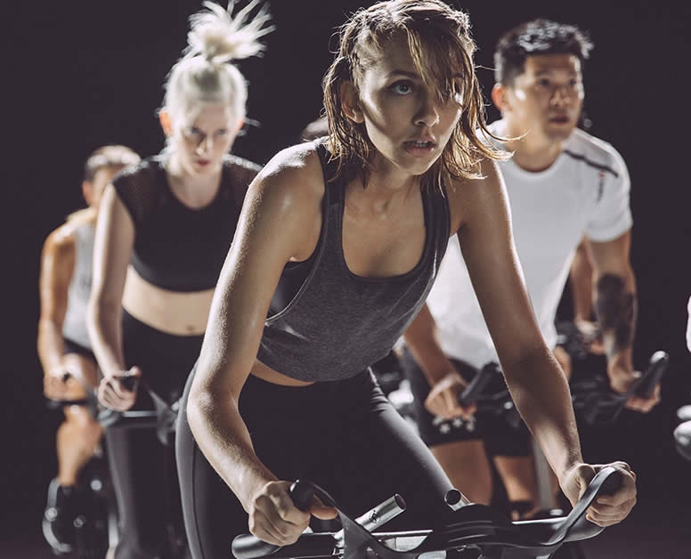 Mujeres y un hombre haciendo spinning